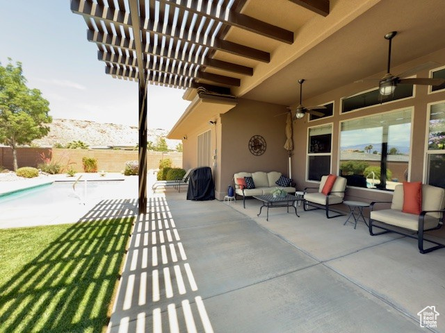 Fenced backyard with outdoor lounge area, ceiling fan, and a patio area