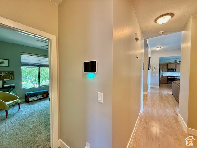 Hall with baseboards and light wood finished floors