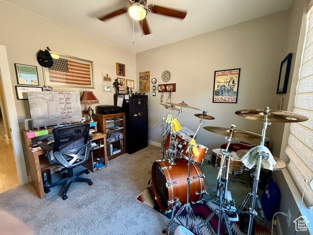 Carpeted office space with a ceiling fan