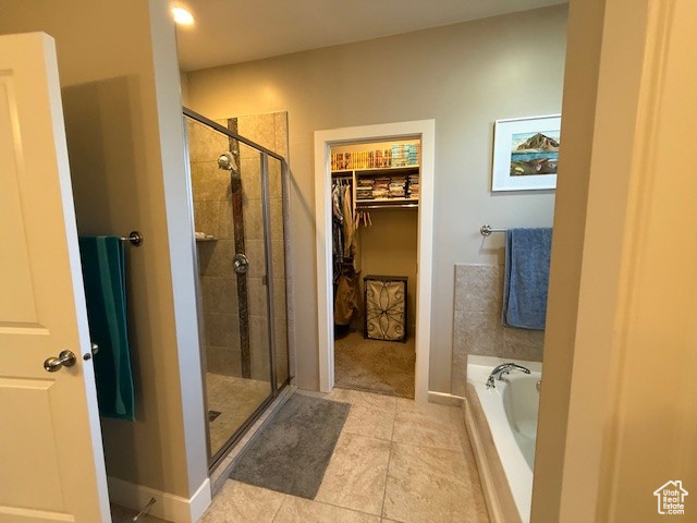 Full bath with a shower stall, a garden tub, tile patterned flooring, and a walk in closet