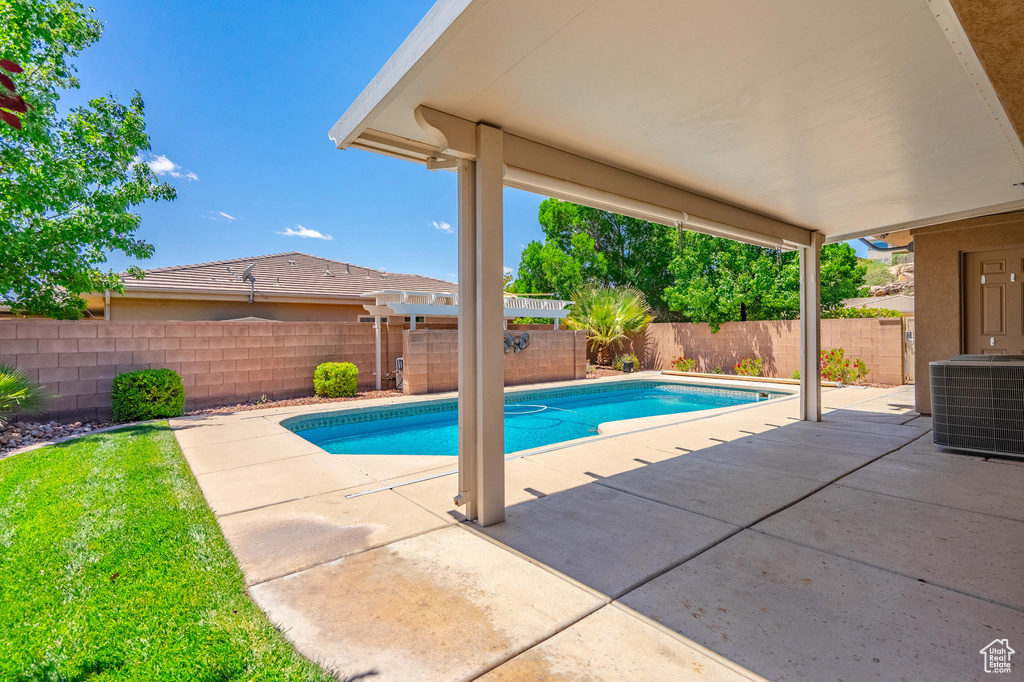 View of pool with a patio, central AC, and a fenced backyard