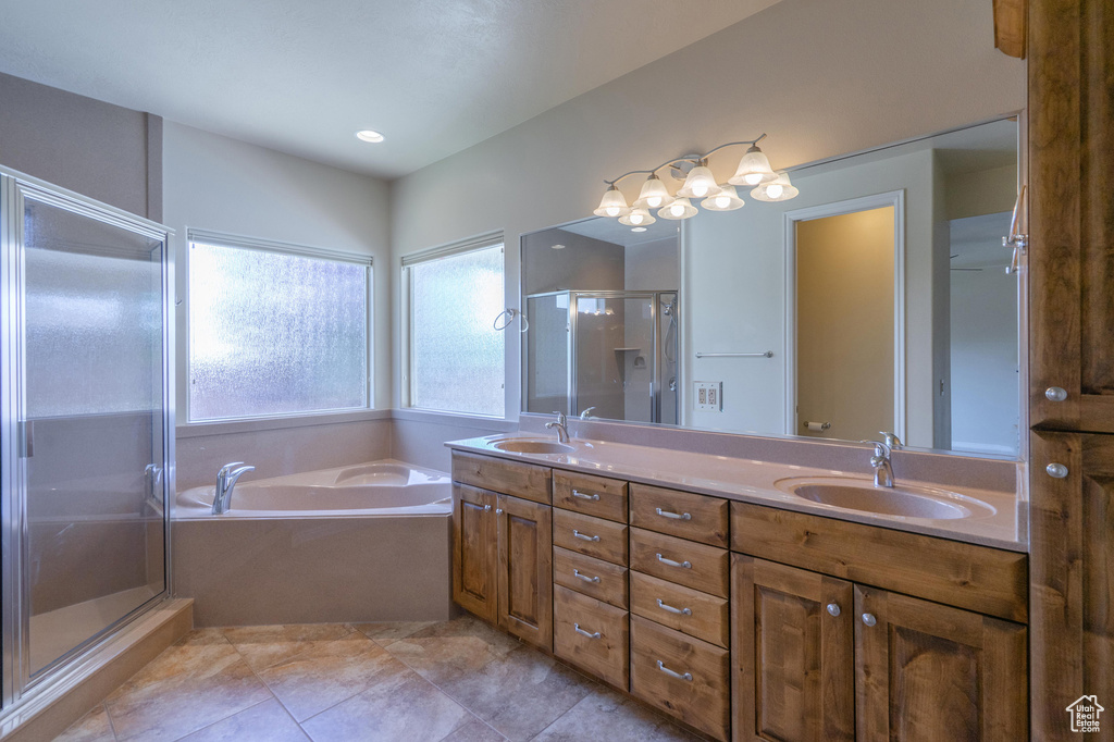 Full bathroom featuring double vanity, a stall shower, and a bath