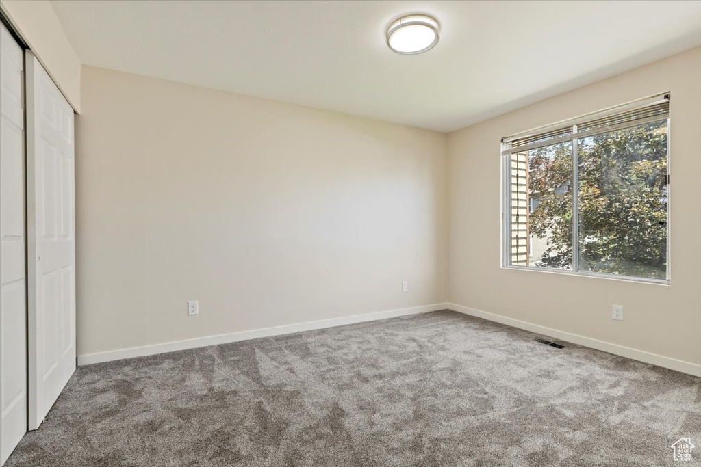 Unfurnished bedroom featuring carpet flooring, baseboards, and a closet