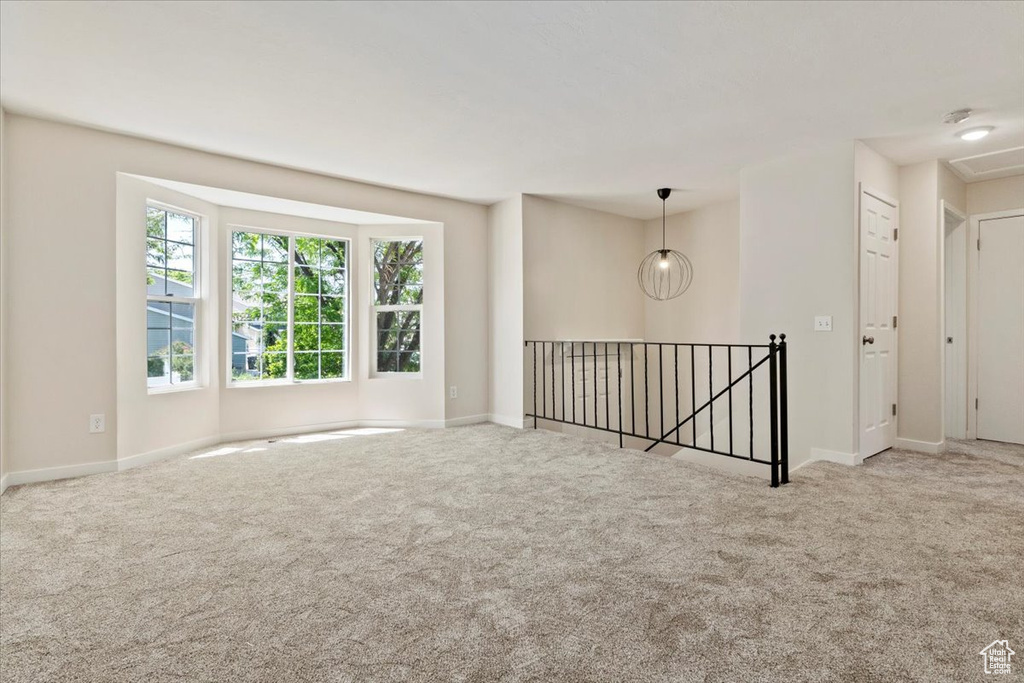 Carpeted spare room featuring baseboards