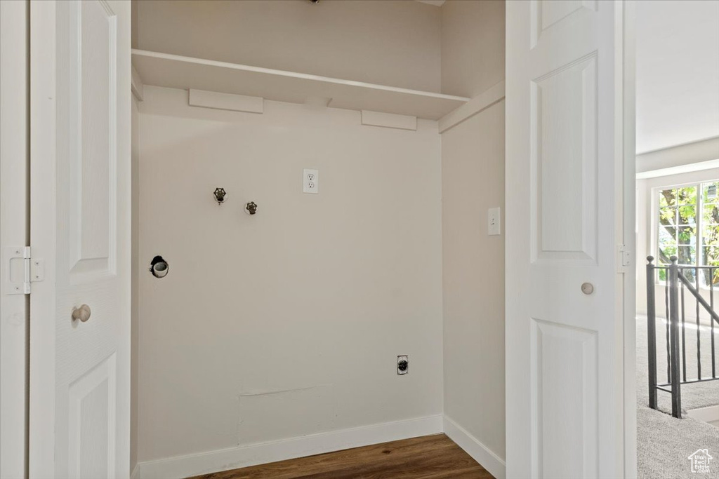 Laundry area featuring hookup for an electric dryer, baseboards, and dark wood finished floors