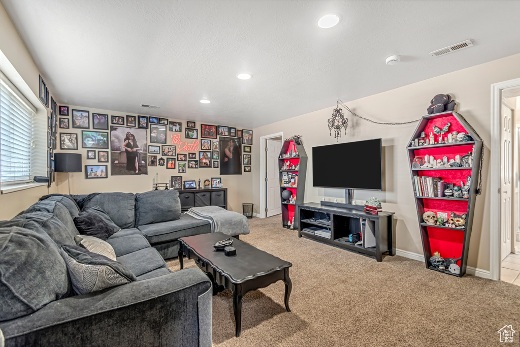 Carpeted living area featuring recessed lighting and baseboards