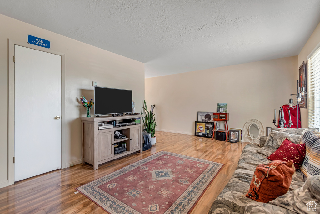 Living area with wood finished floors and a textured ceiling