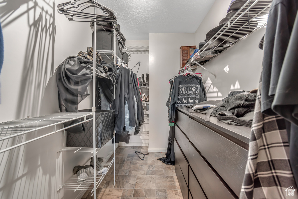 Spacious closet with light stone finish flooring