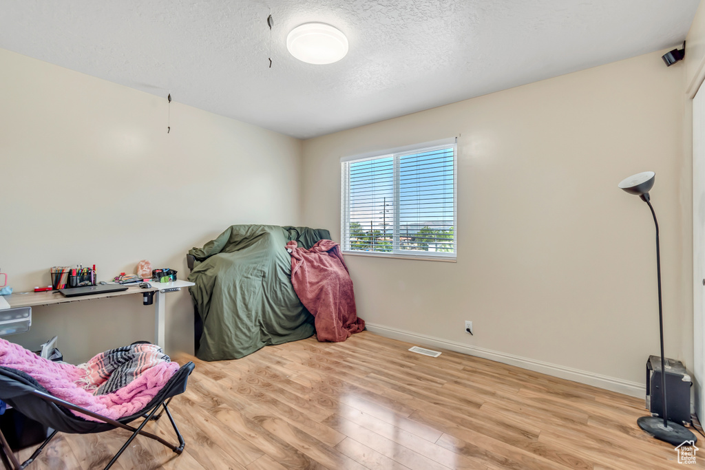 Miscellaneous room with wood finished floors, baseboards, and a textured ceiling