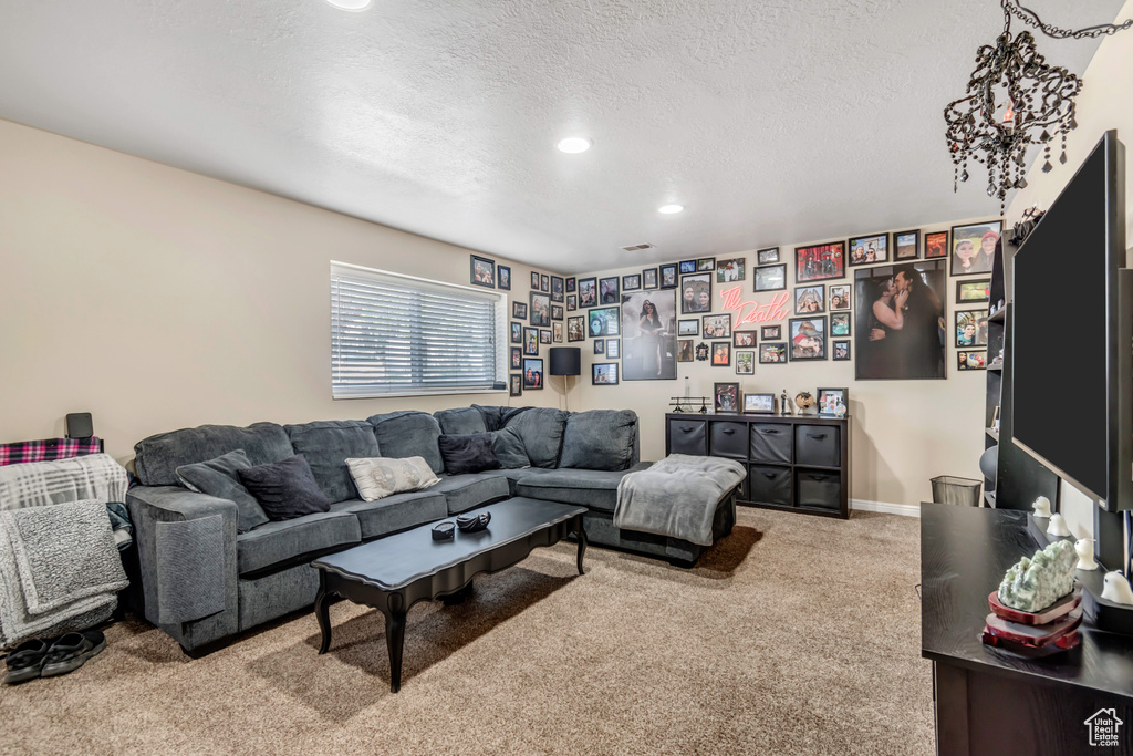 Carpeted living area featuring a textured ceiling and recessed lighting