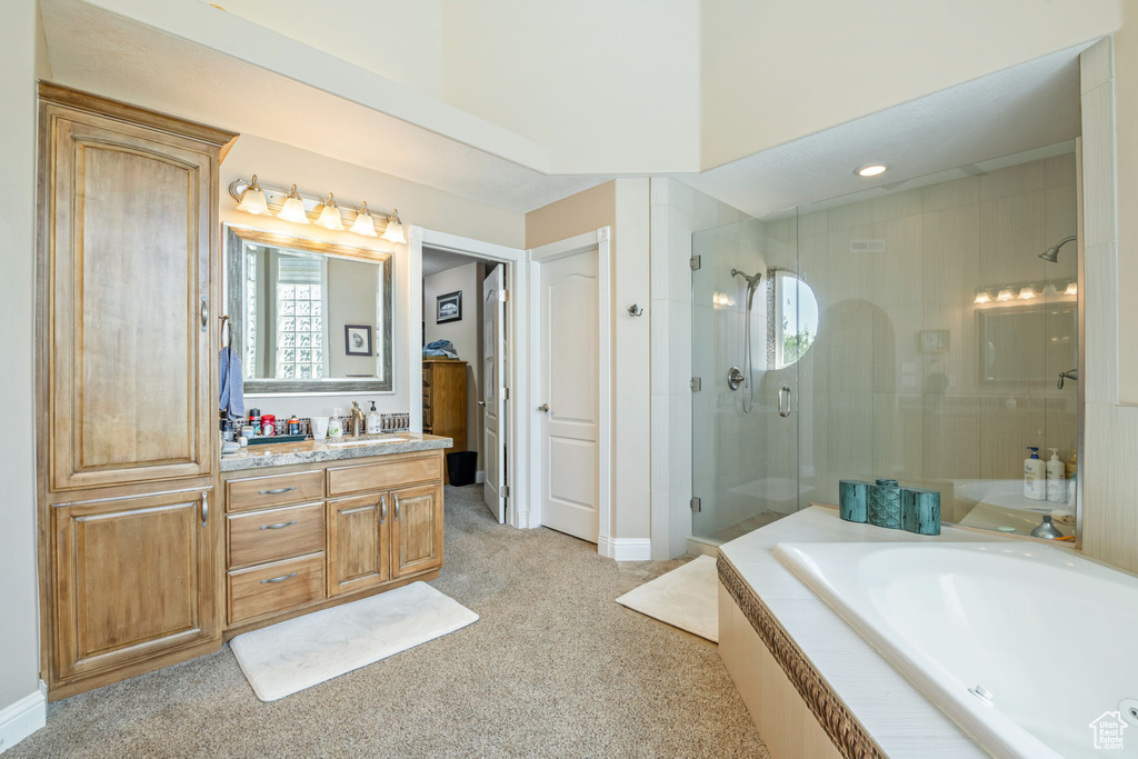 Full bath featuring a shower stall, vanity, and a garden tub