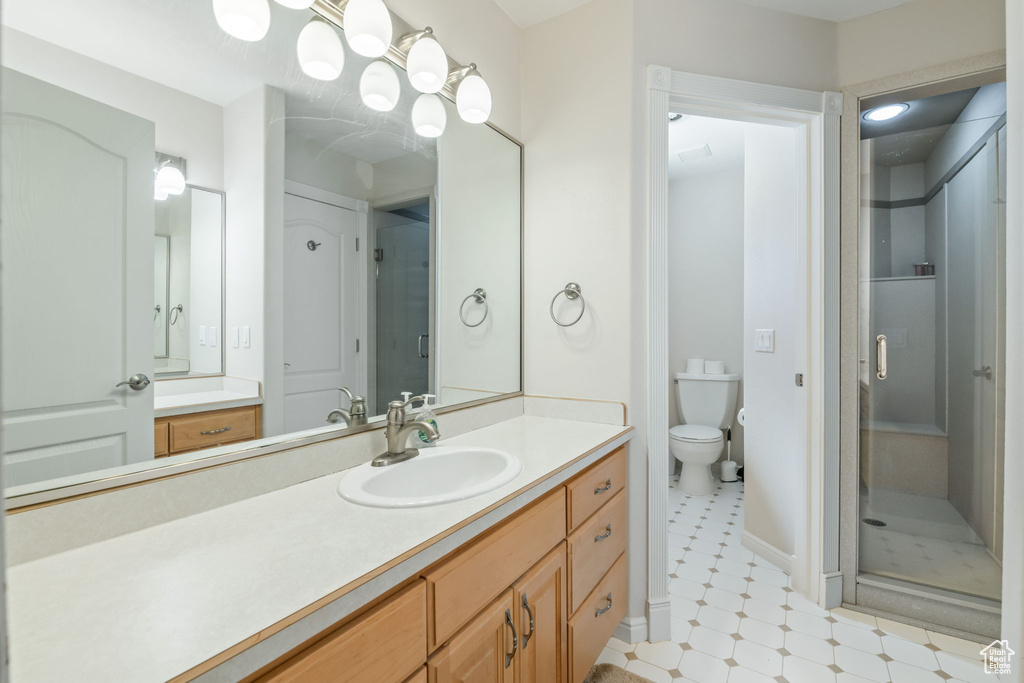 Bathroom featuring a shower stall, vanity, and tile patterned floors