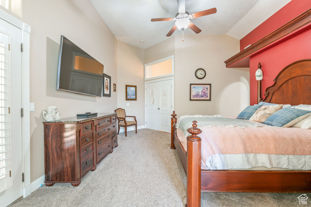 Bedroom with light colored carpet, lofted ceiling, and a ceiling fan