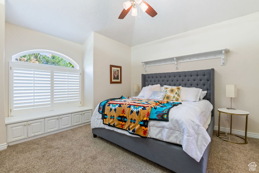 Carpeted bedroom with lofted ceiling and a ceiling fan