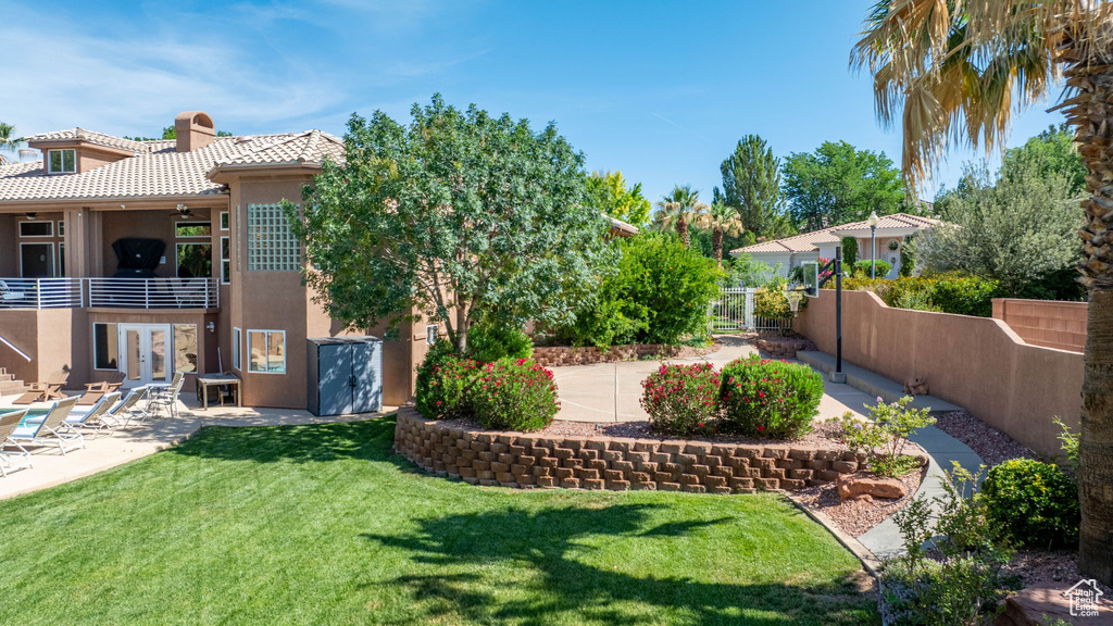View of yard featuring a balcony, french doors, and a patio
