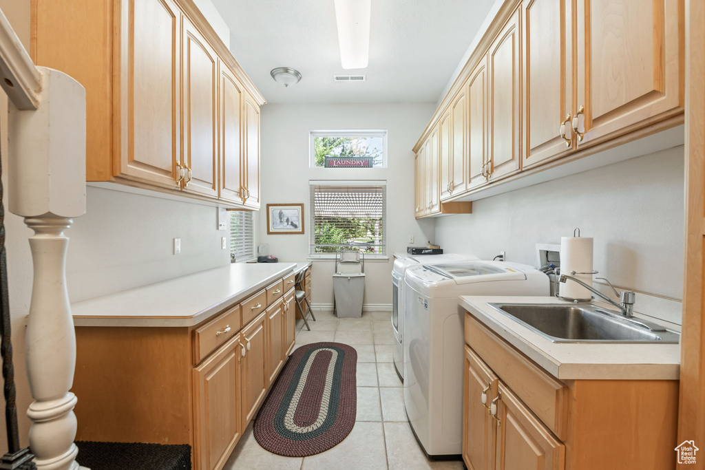 Washroom with washer and clothes dryer, cabinet space, and light tile patterned flooring