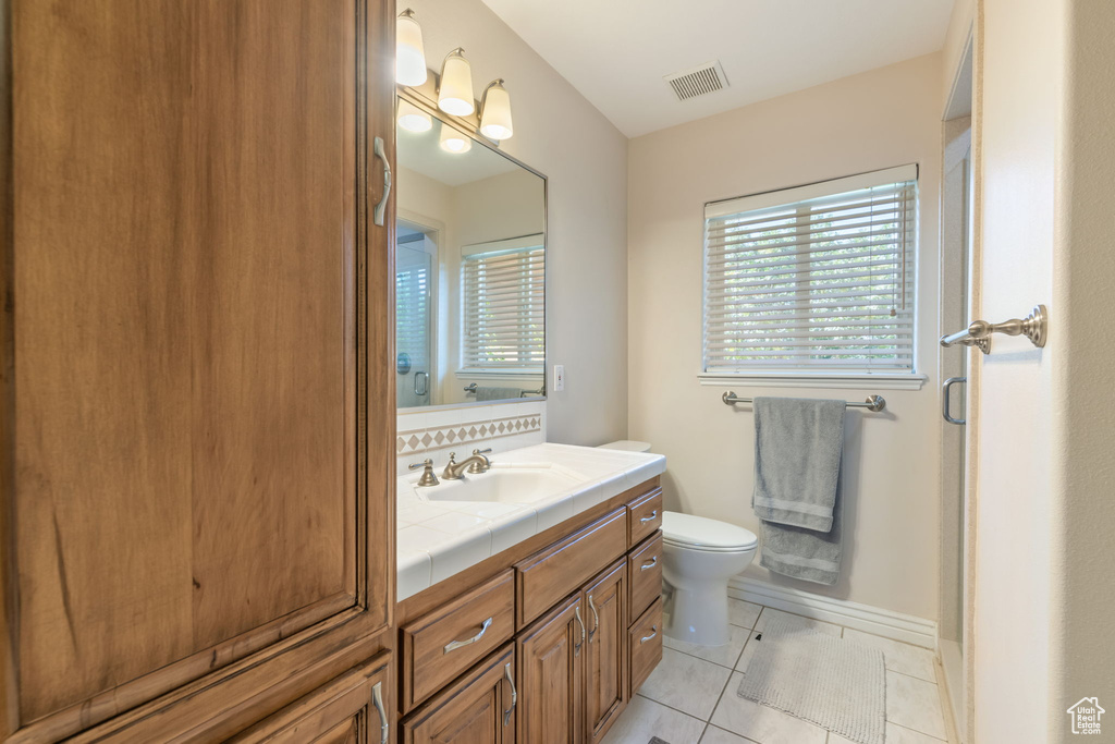 Bathroom with healthy amount of natural light, vanity, and tile patterned floors