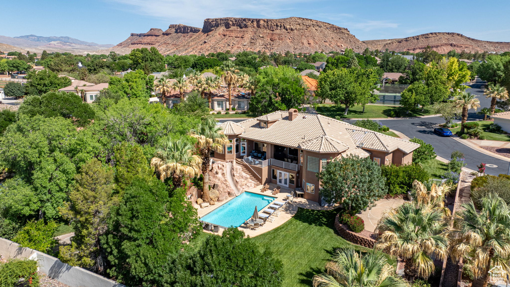 Aerial view of property and surrounding area with a mountain backdrop