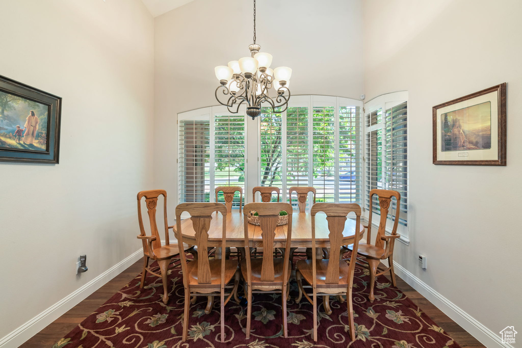 Dining room featuring a chandelier, dark wood finished floors, and high vaulted ceiling
