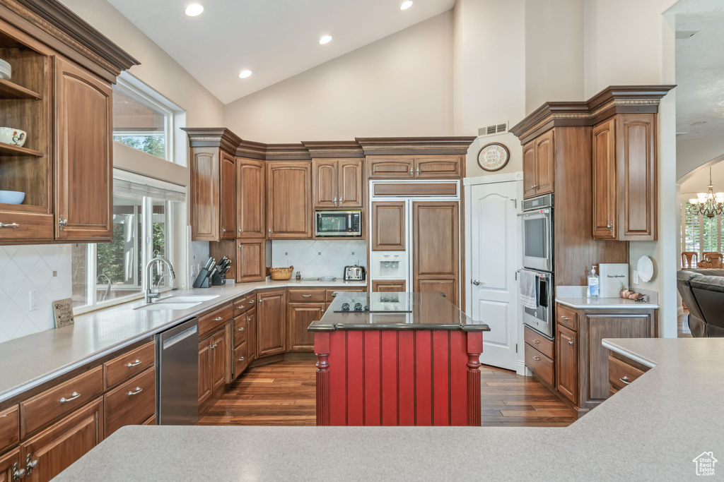 Kitchen featuring built in appliances, dark wood-style floors, high vaulted ceiling, tasteful backsplash, and open shelves