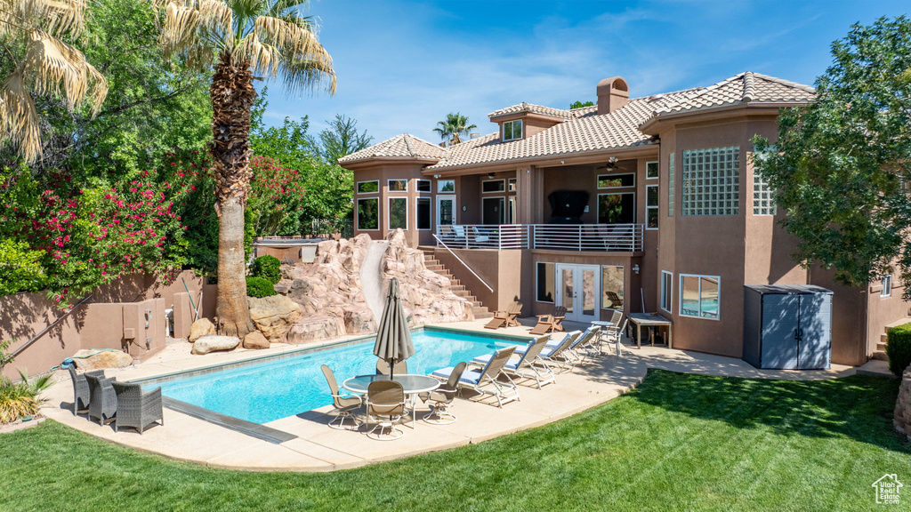 View of swimming pool with stairway, a lawn, a patio area, and ceiling fan