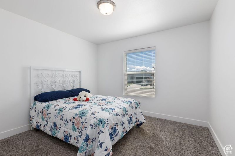 Bedroom featuring carpet flooring and baseboards