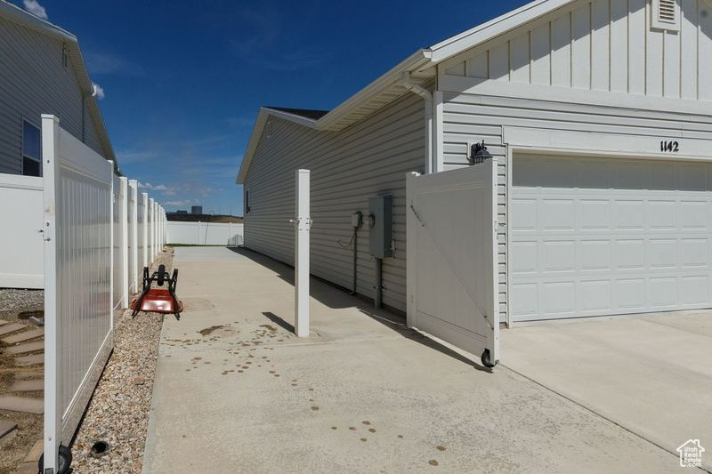 View of side of home featuring board and batten siding, driveway, and a garage