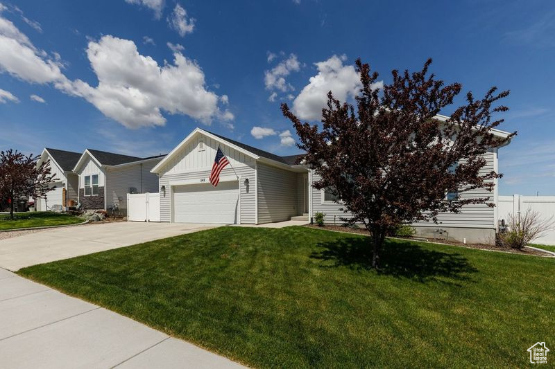 View of front of house with concrete driveway, board and batten siding, and a garage