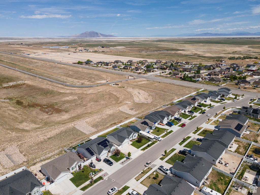 Aerial overview of property's location with a mountain backdrop and nearby suburban area