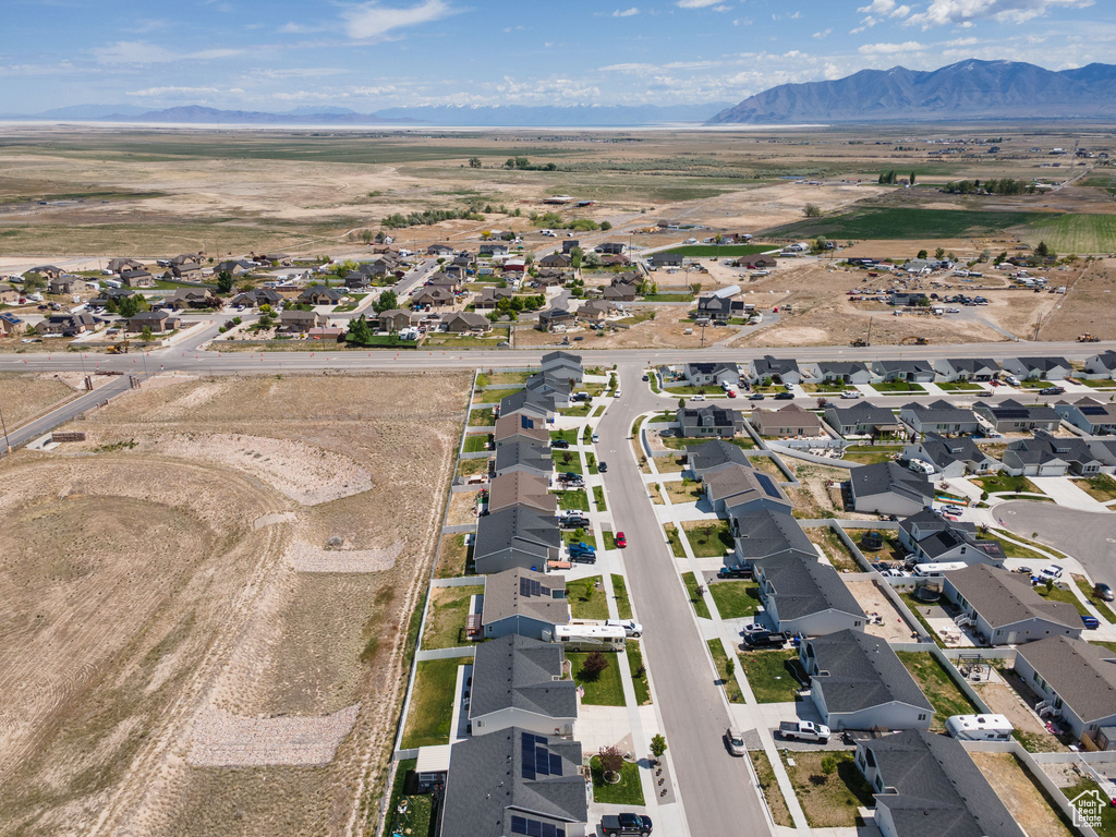 Aerial view of property and surrounding area with a mountain backdrop and nearby suburban area