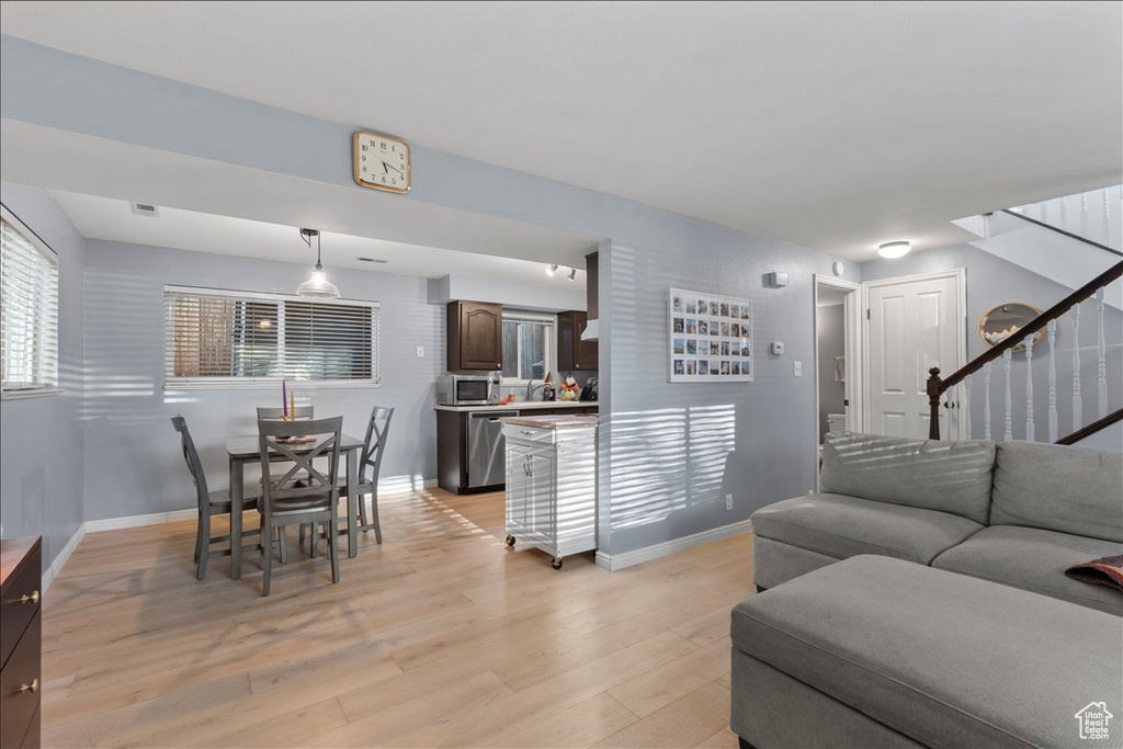 Living area featuring stairway, light wood finished floors, and baseboards