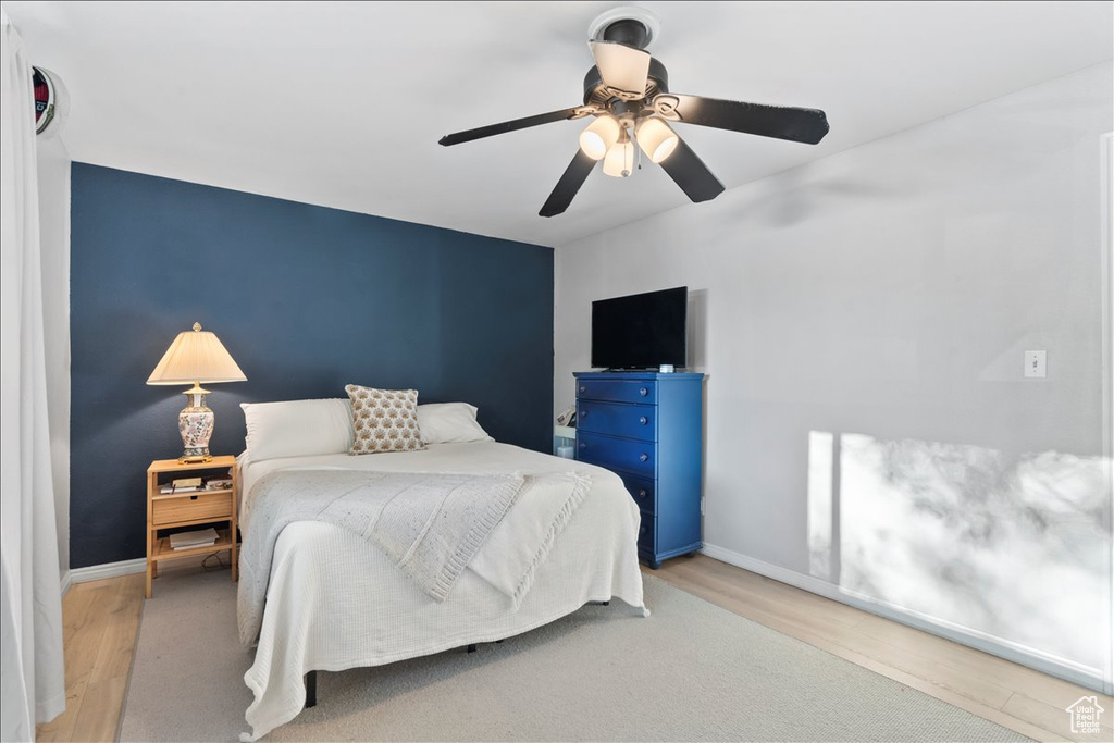 Bedroom with wood finished floors, baseboards, and ceiling fan