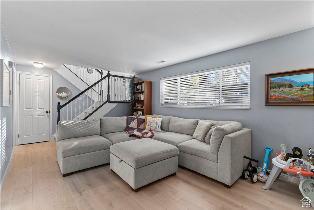 Living room featuring light wood-style flooring and stairs