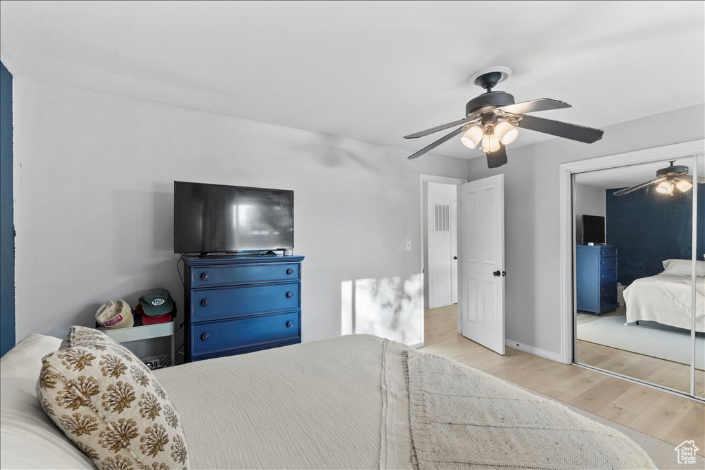 Bedroom with wood finished floors, a closet, ceiling fan, and baseboards