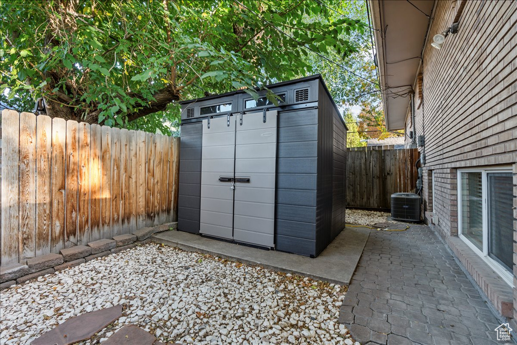 View of shed featuring cooling unit and a fenced backyard