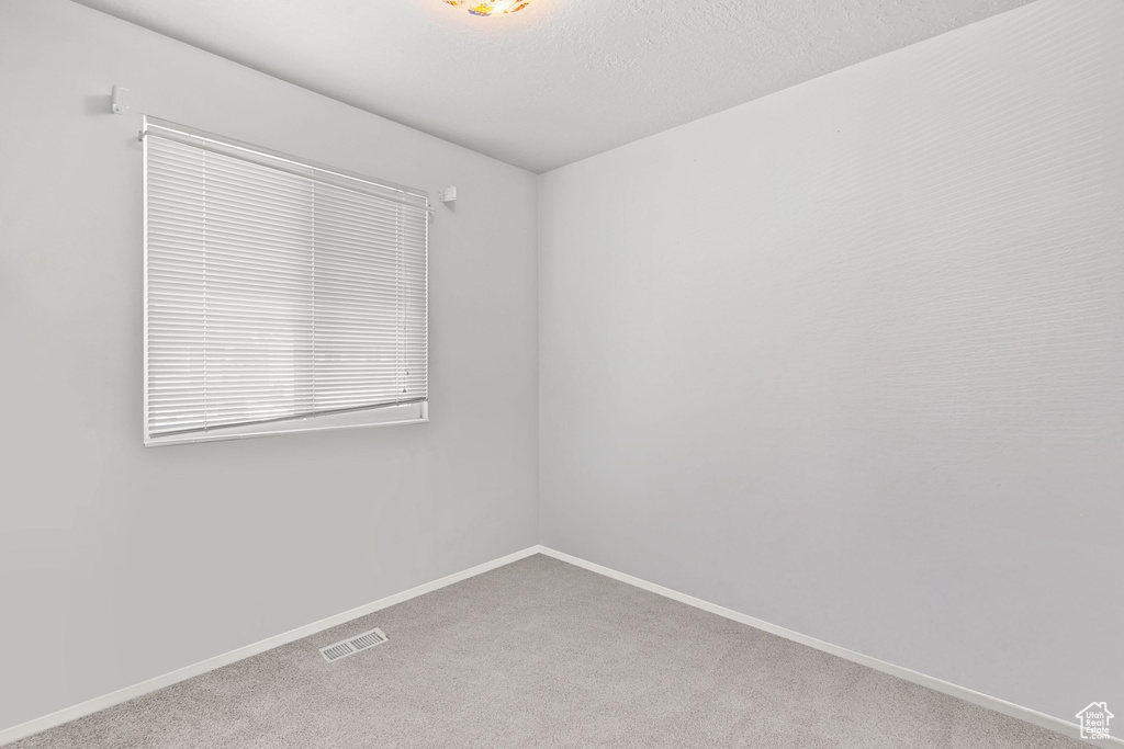 Empty room with carpet and baseboards