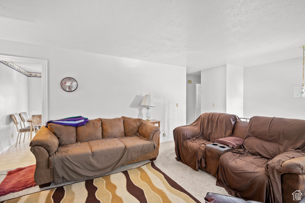 Living area featuring a textured ceiling and a chandelier