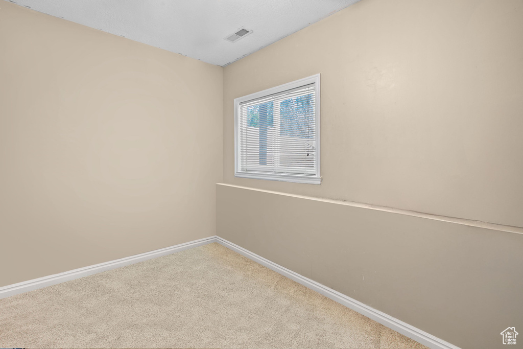 Spare room featuring carpet floors and baseboards