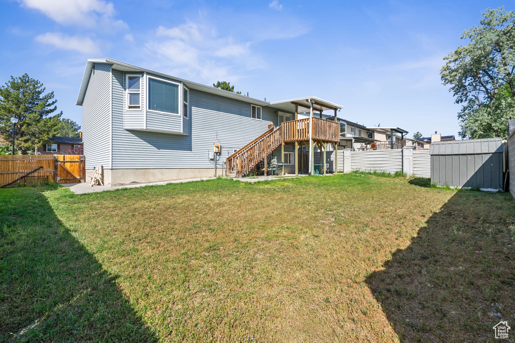 Back of property featuring stairs, a gate, and a deck
