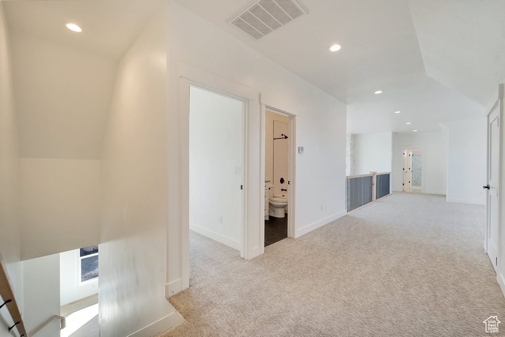 Hall featuring light carpet, recessed lighting, baseboards, an upstairs landing, and vaulted ceiling