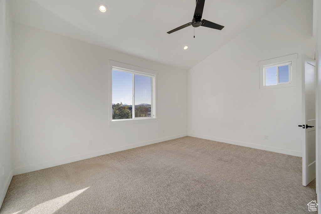 Spare room with plenty of natural light, light colored carpet, a ceiling fan, lofted ceiling, and recessed lighting