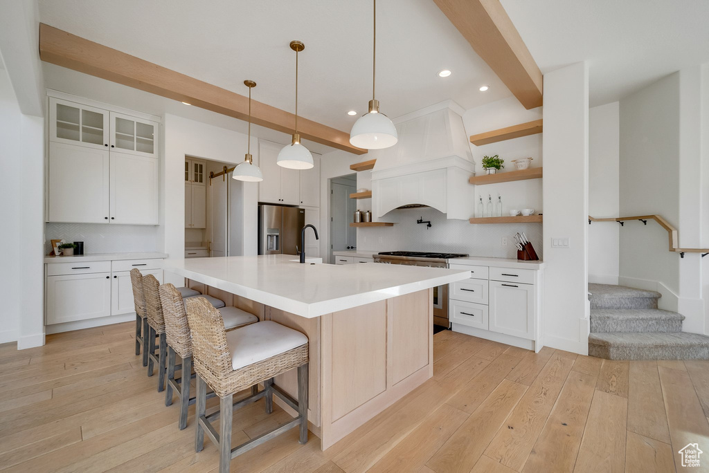 Kitchen featuring open shelves, appliances with stainless steel finishes, light wood-type flooring, custom exhaust hood, and recessed lighting