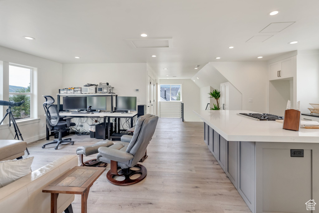 Home office with recessed lighting, light wood-style flooring, attic access, and baseboards