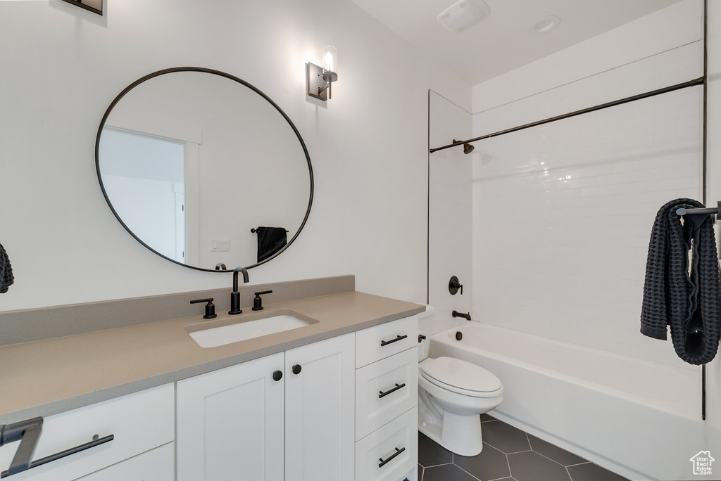 Bathroom featuring vanity, toilet, tile patterned floors, and shower / bathtub combination