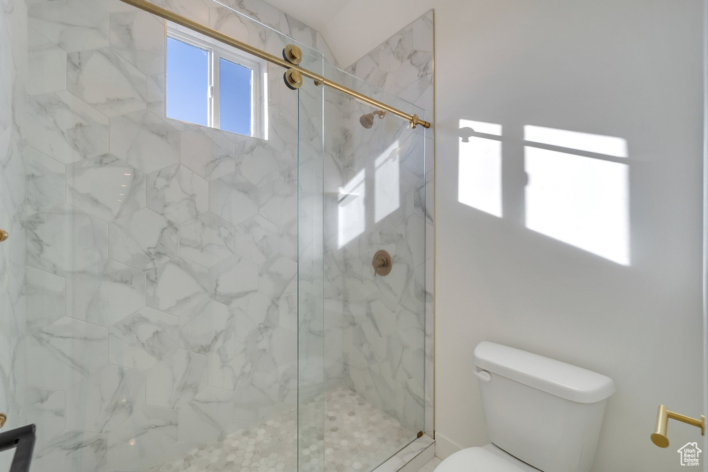 Bathroom with toilet and a marble finish shower
