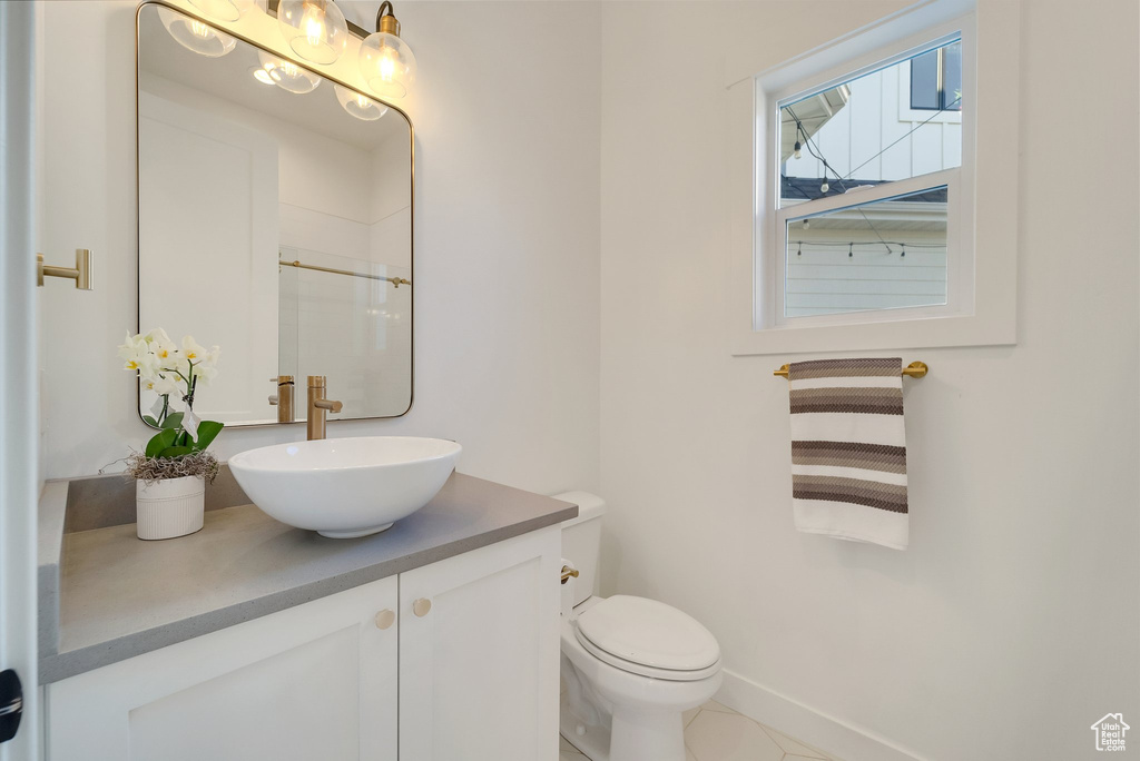 Full bathroom featuring vanity, toilet, a shower, and baseboards