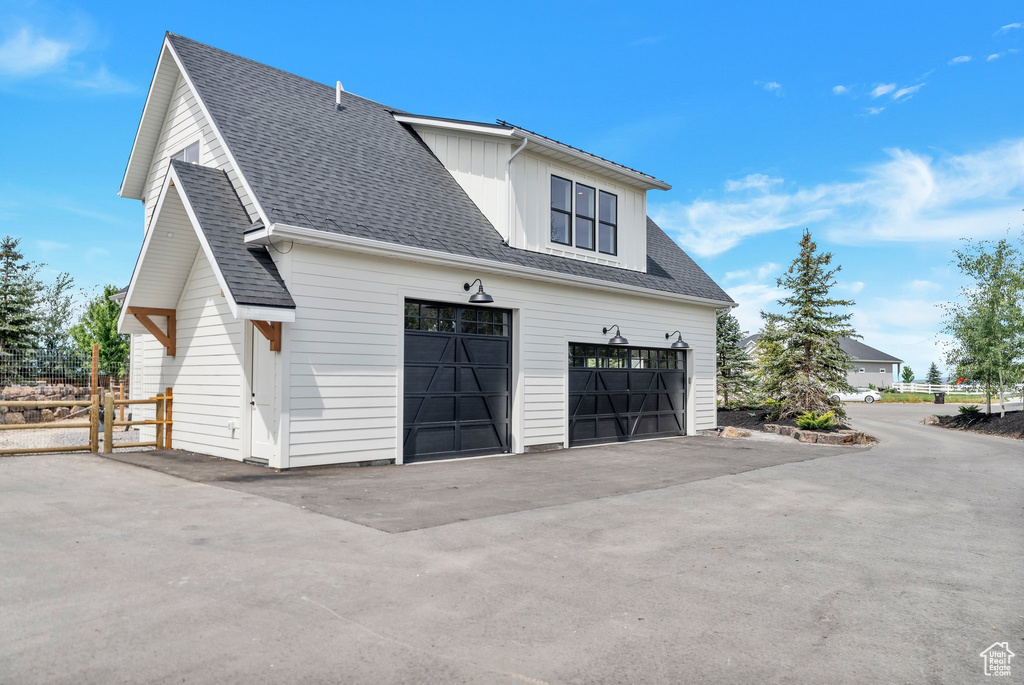 View of property exterior featuring roof with shingles and board and batten siding