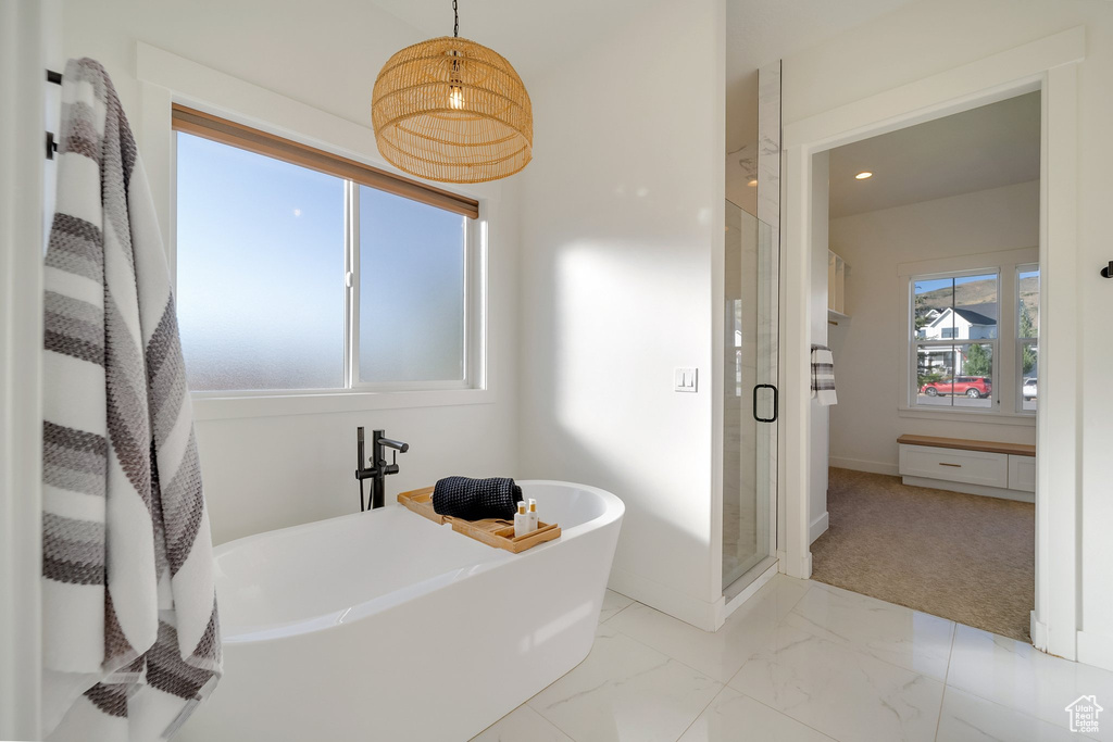 Full bath with a shower stall, a freestanding tub, marble look tiles, baseboards, and recessed lighting
