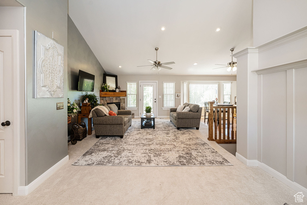 Carpeted living room featuring ceiling fan, baseboards, a fireplace, recessed lighting, and high vaulted ceiling