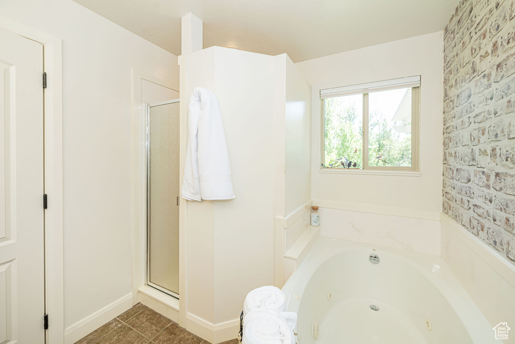 Full bath with a whirlpool tub, a shower stall, and baseboards